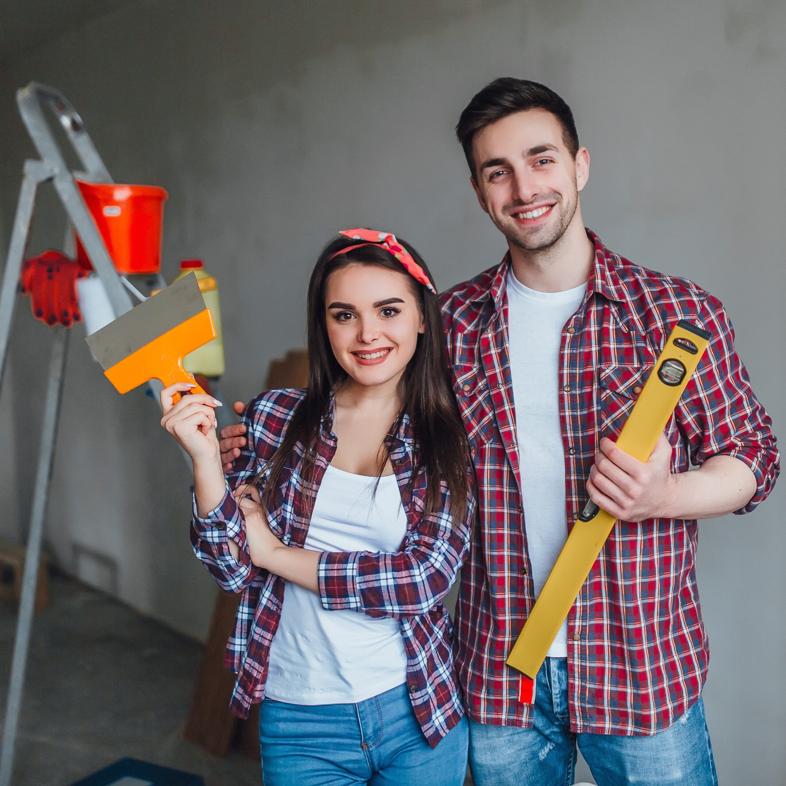 pretty happy woman looking front with her husband while they are doing repair