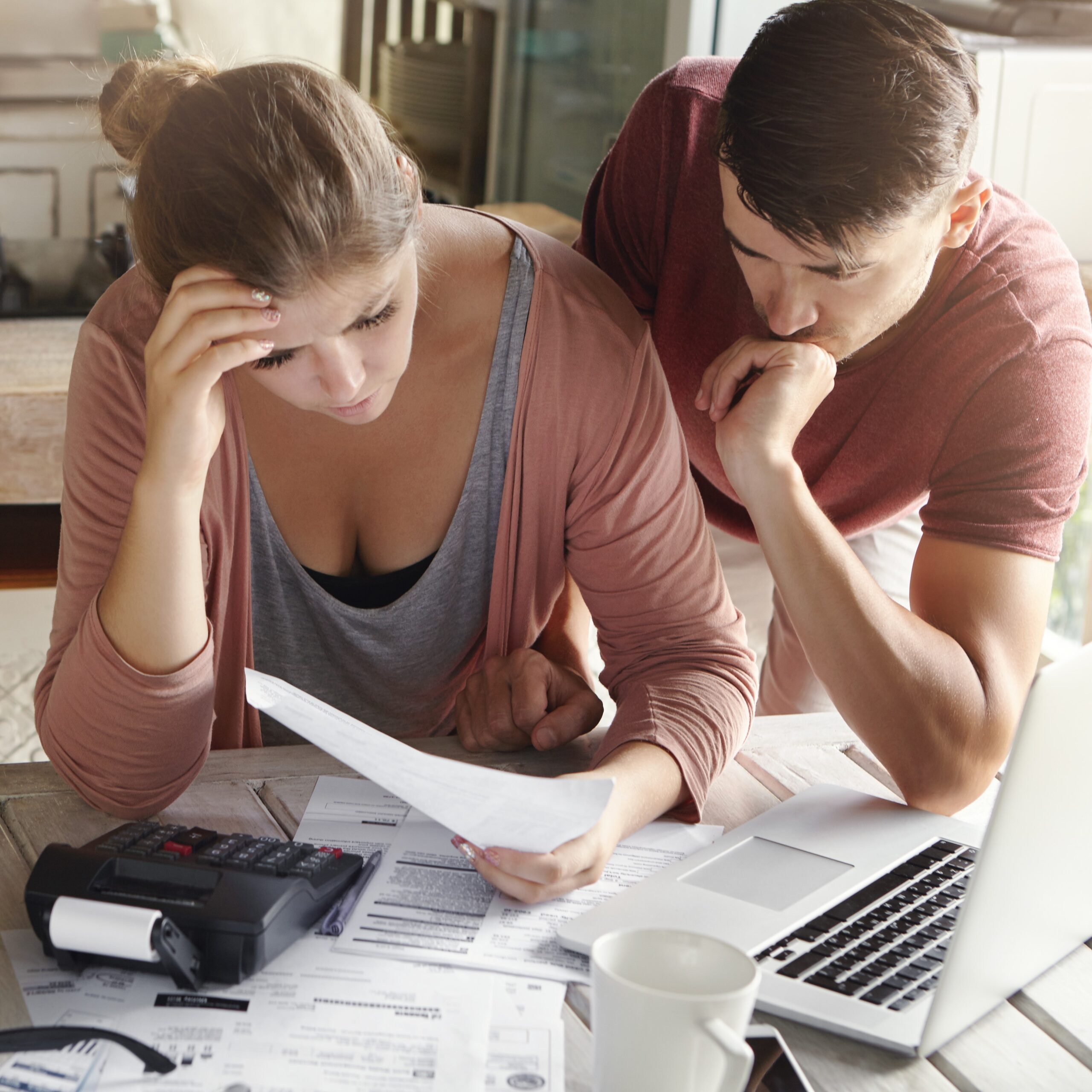 worried couple reviewing their family finances calculating expenses